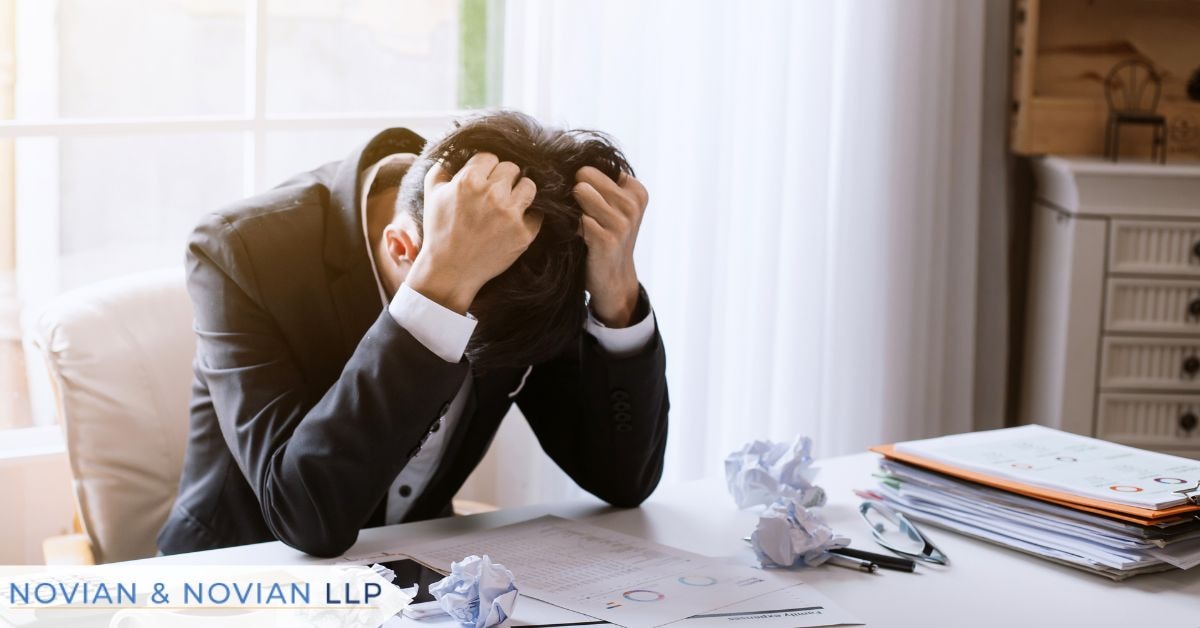 Impact of an EEOC complaint on a business — stressed employer reviewing paperwork